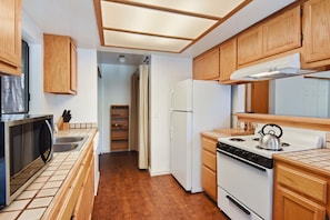 Open Kitchen with Electric Stove, Oven, and Refrigerator