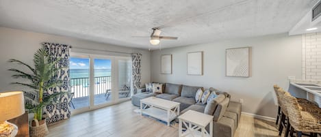 Living area with ample, comfortable seating, large flatscreen television, and views of the Gulf of Mexico. Also an additional bar top eating area.