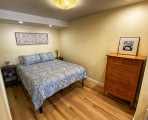 Queen size bed with dresser. The TV can be turned to be viewable from the bed.
