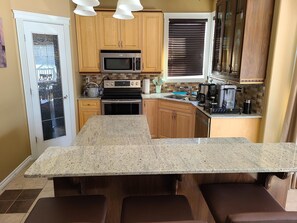 Kitchen island and pantry with basics like flour, sugar, spices, pasta.