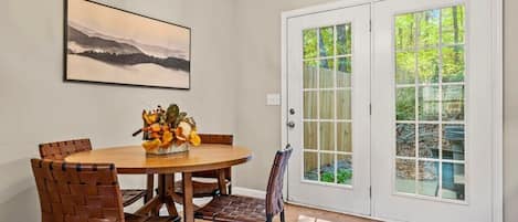 Your dining area offers the perfect backdrop for enjoying delicious meals with loved ones, with a large glass door showcasing the serene back patio and inviting hot tub.