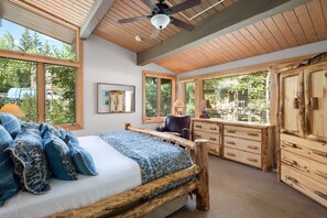 The master bedroom is spacious and bright with many windows and vaulted ceilings.