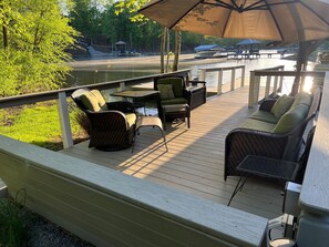 Deck seating down by the lake, with large shade