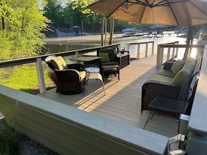 Deck seating down by the lake, with large shade