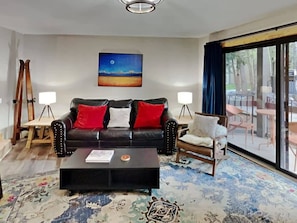 The fabulous living room is outfitted with a leather couch, cozy armchair, coffee table, end tables, lamps, media console and a 55-inch smart TV. When needed, the couch converts into a queen-size, pullout bed.