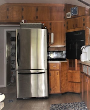 Cozy kitchen.  Handcrafted cabinets by a previous owner. Stainless sink and ref