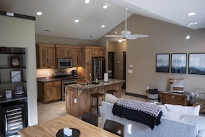 Open-concept kitchen, dining, and living spaces with vaulted ceiling