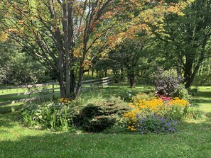 Fully fenced in back yard with flower garden and picnic table.