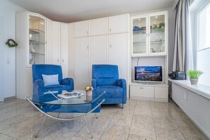 Kombinierter Wohn-/Schlafraum mit Sessel und Schrankbett
