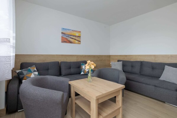 Living area with coffee table, two armchairs and two double sofa beds.