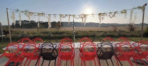 Ein großer Tisch im Garten auf der Terrasse mit Blick auf Wald und Wiese.