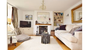 Cosy sitting room with large squashy sofa and woodburner.