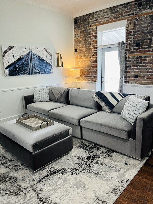 Cozy living area in historic building with exposed brick; access to balcony