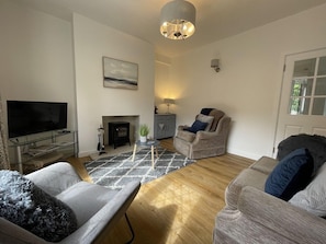 The cosy front room is furnished with a 2 seater sofa and 2 chairs
