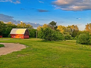 Exterior Retreat: Charming red barn surrounded by lush greenery, perfect for photos and relaxation!