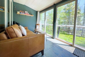 The four-season porch adds to the living space, and we love the view through the trees and out to the lake.