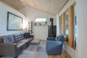 The living area has a full-size couch, comfy swivel chair, both with views out on to the lake and the warmth of the gas fireplace.
