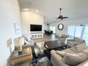 Living room - Open concept with 75 in ROKU TV and lake views. 