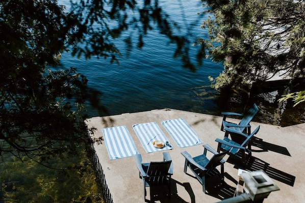 Enjoy your coffee in the sunshine on our concrete dock - spanning 150 feet of waterfront and featuring incredible East facing views of Crown Land, islands, and beautiful cottages on Charleston Lake.