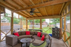 Our backyard offers a spacious & screened haven, complete w/ a TV and bar setup.