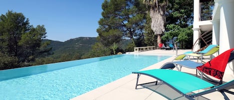 Piscine, plage, chaises longues vue montagne, jardin