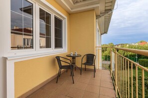 Furnished balcony with green surroundings. 