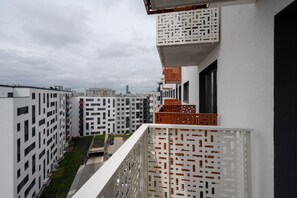 Balcony view overlooking a vibrant residential complex and cityscape.
