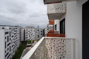 Balcony view overlooking a vibrant residential complex and cityscape.