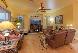 Great room has plush seating to view and enjoy the freestanding fireplace and TV.