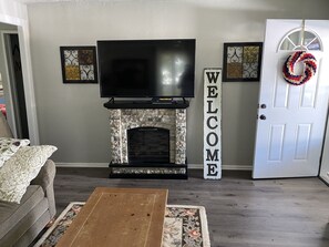 Living room / front door with electric fireplace