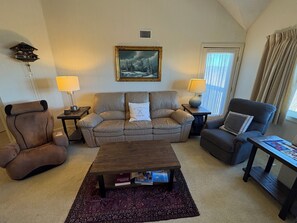 Open family room with recliners, fireplace, TV and massage chair.