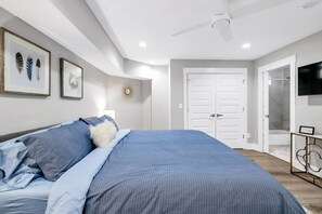 Retreat to our spacious bedroom, boasting a king-size bed with luxurious blue bedding, designed for your utmost comfort. The room is complete with modern amenities and elegant decor, ensuring a restful and stylish stay.