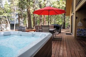 Unwind on the back deck with a soak in the private hot tub under the trees.
