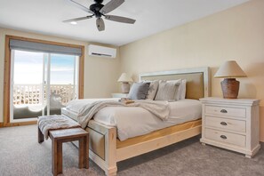 Main bedroom suite with king bed, wooden and fabric headboard, wooden side tables and bedroom  bench