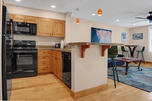 Fully equipped kitchen with over the range microwave, opening to the dining room