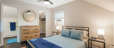 Bedroom with walk in closet and dresser with view into bathroom. Attic storage crawl space useful for longer stays.