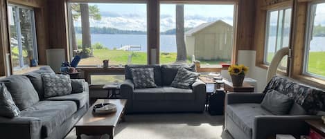 Enjoy lake views with windows on three sides of the living room with large TV.