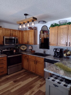 Well stocked kitchen and mirrored sink area reflects the open water view