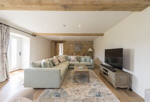 Furlongs, Abbotsbury: Sitting / Drawing room with exposed beams and stone wall