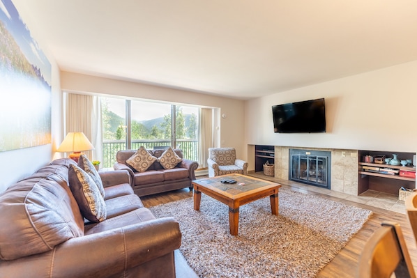 Living area featuring a gas fireplace, mounted TV, and sleeper sofa for additional sleeping options.