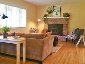 Bright living room with vineyard views, and a wood stove for cozy winter stays.