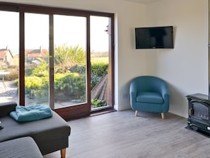 Open-aspect living space with wood-burning stove | Eider Cottage, Embleton