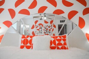 The master bedroom features off the hook orange wall accents and a 70s headboard on a King size bed!