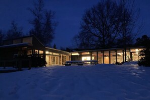 The house lit up on a winter night.