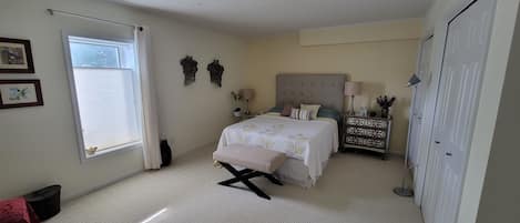 bedroom  with Queen bed, 2 night tables and a bench (1)
