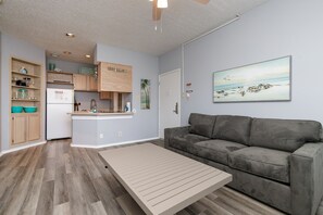 Living area with queen size sleeper sofa and coffee table that pulls up into the dining table