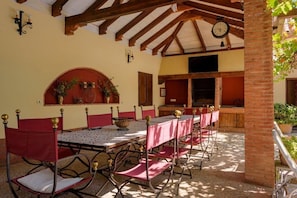 Outside, there is a large table for 10 people next to the barbecue.