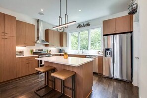 Fully stocked kitchen with gas range and double oven.