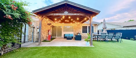 Nice backyard with a gazebo, an 8-person dining set, corn hole, and kid's toys.