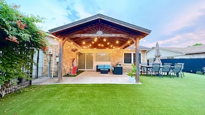 Nice backyard with a gazebo, an 8-person dining set, corn hole, and kid's toys.